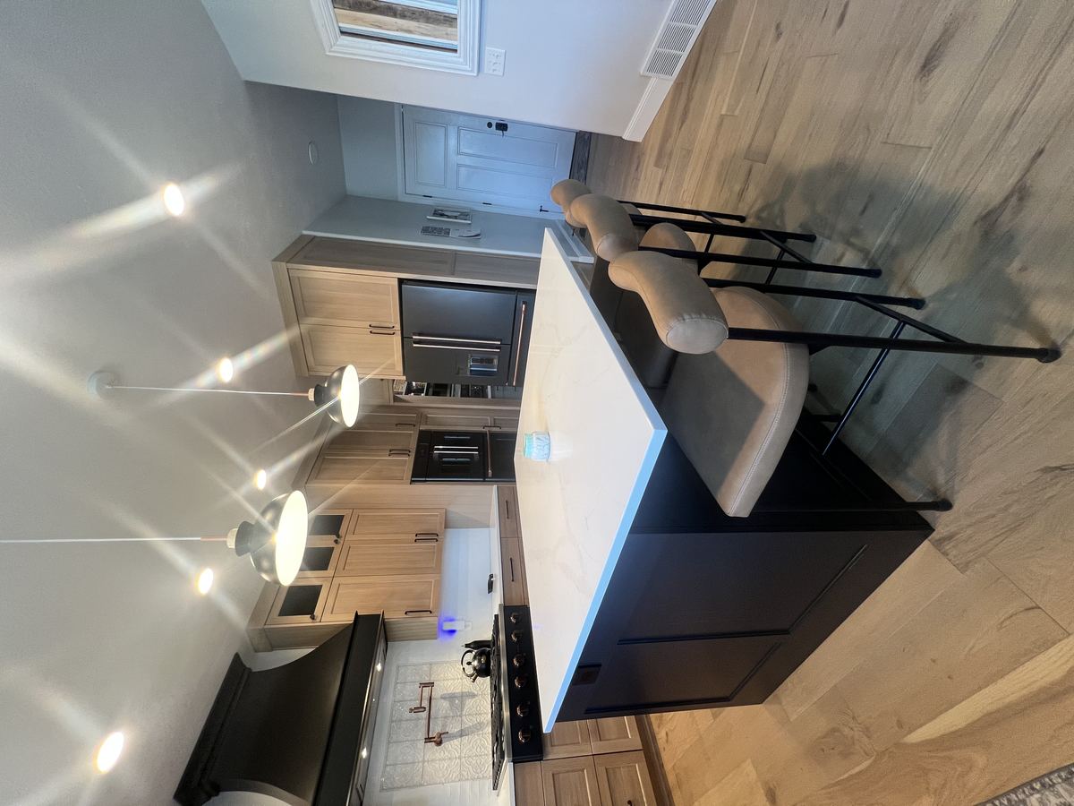 Finished kitchen with oak cabinetry and a dark island